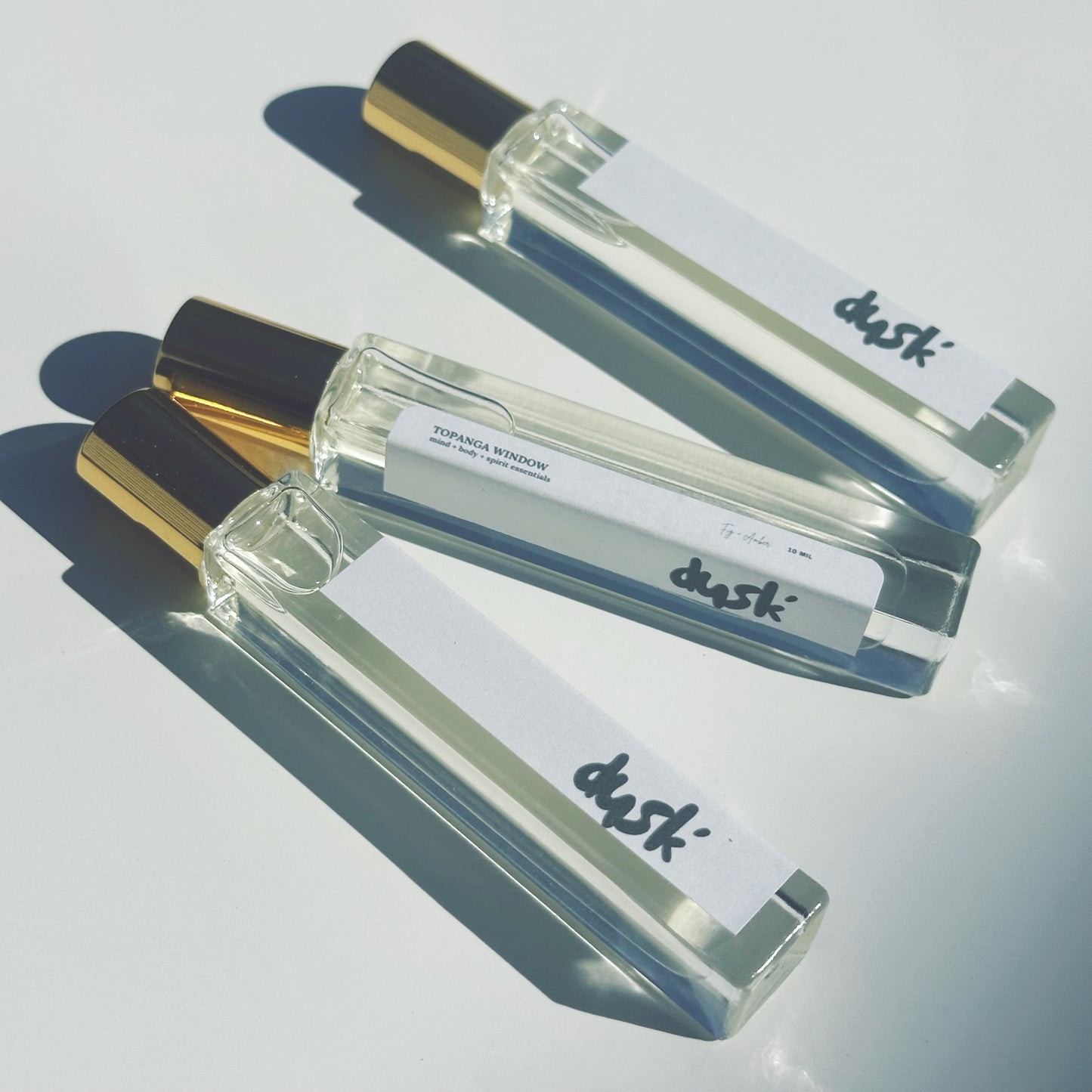 perfume clear roll on bottle with gold cap and metal roller