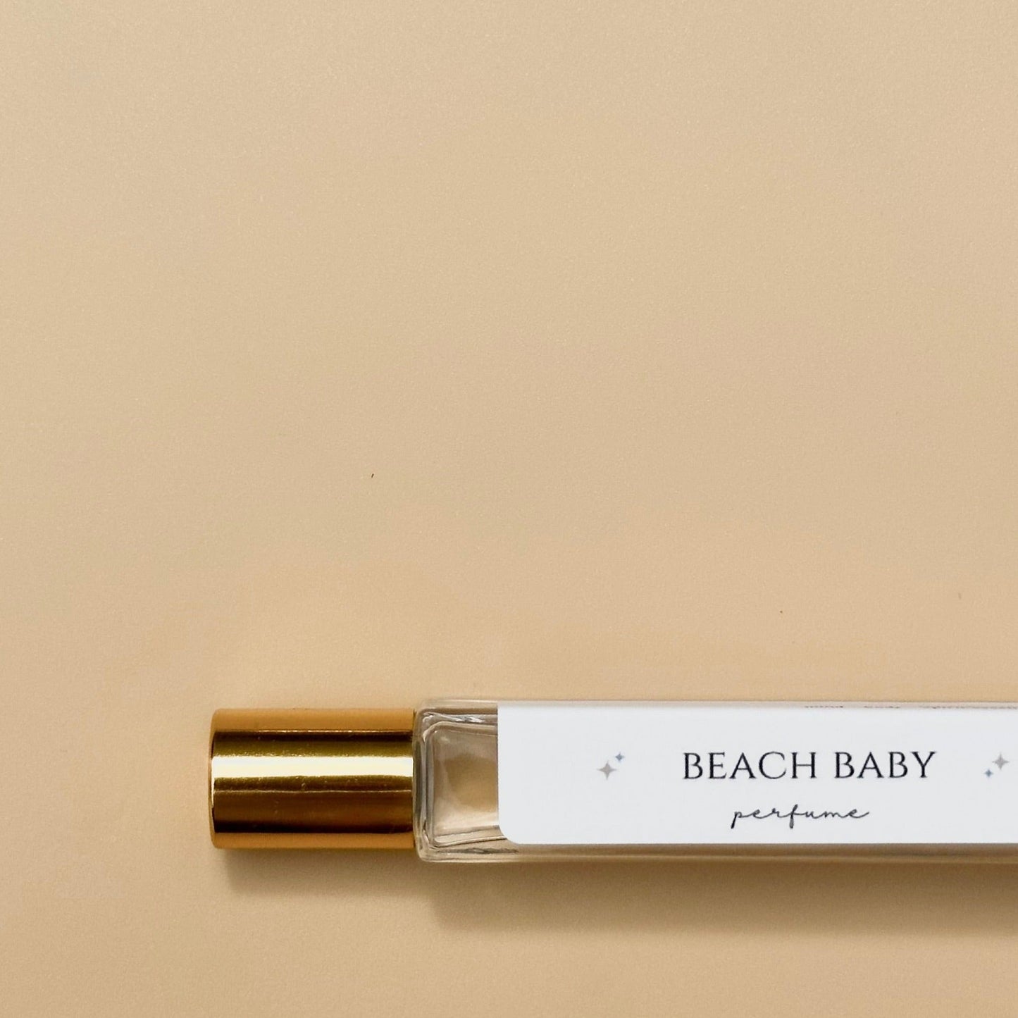 beach perfume roll on bottle. yellow background glass bottle with gold top