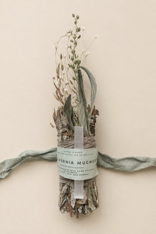 Decorative bundle of dried plants with a label on a white background