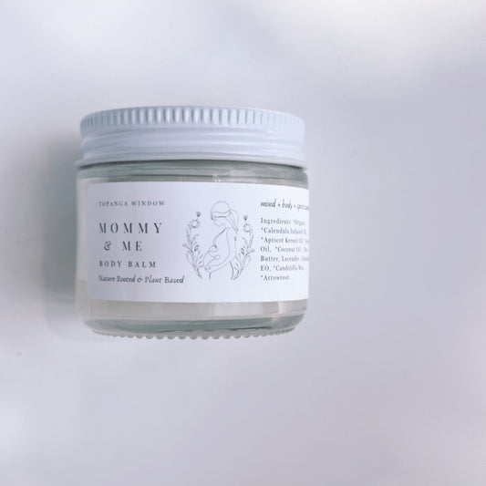 Jar of 'Mommy & Me' body balm with a white label on a light gray background