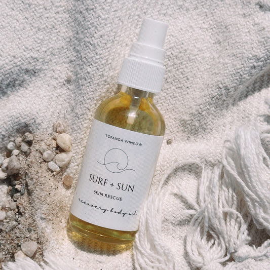 Body oil on beach blanket with sand and pebbles