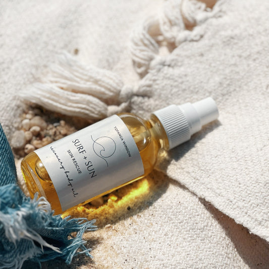 golden body oil bottle a beach  blanket