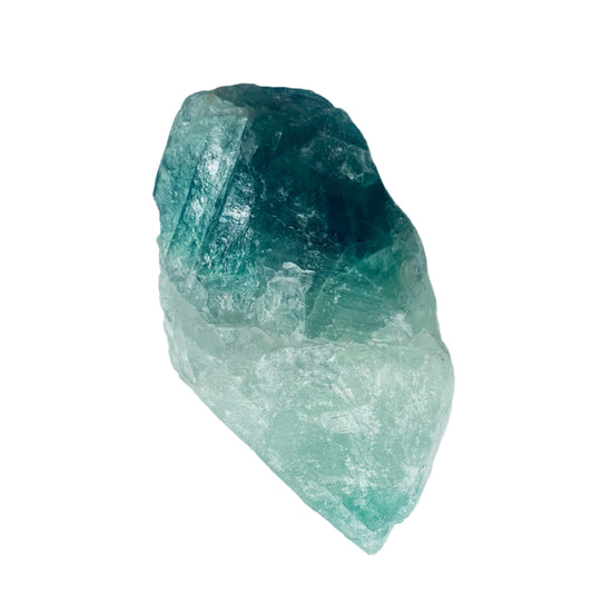 A polished raw green fluorite healing stone against a white background