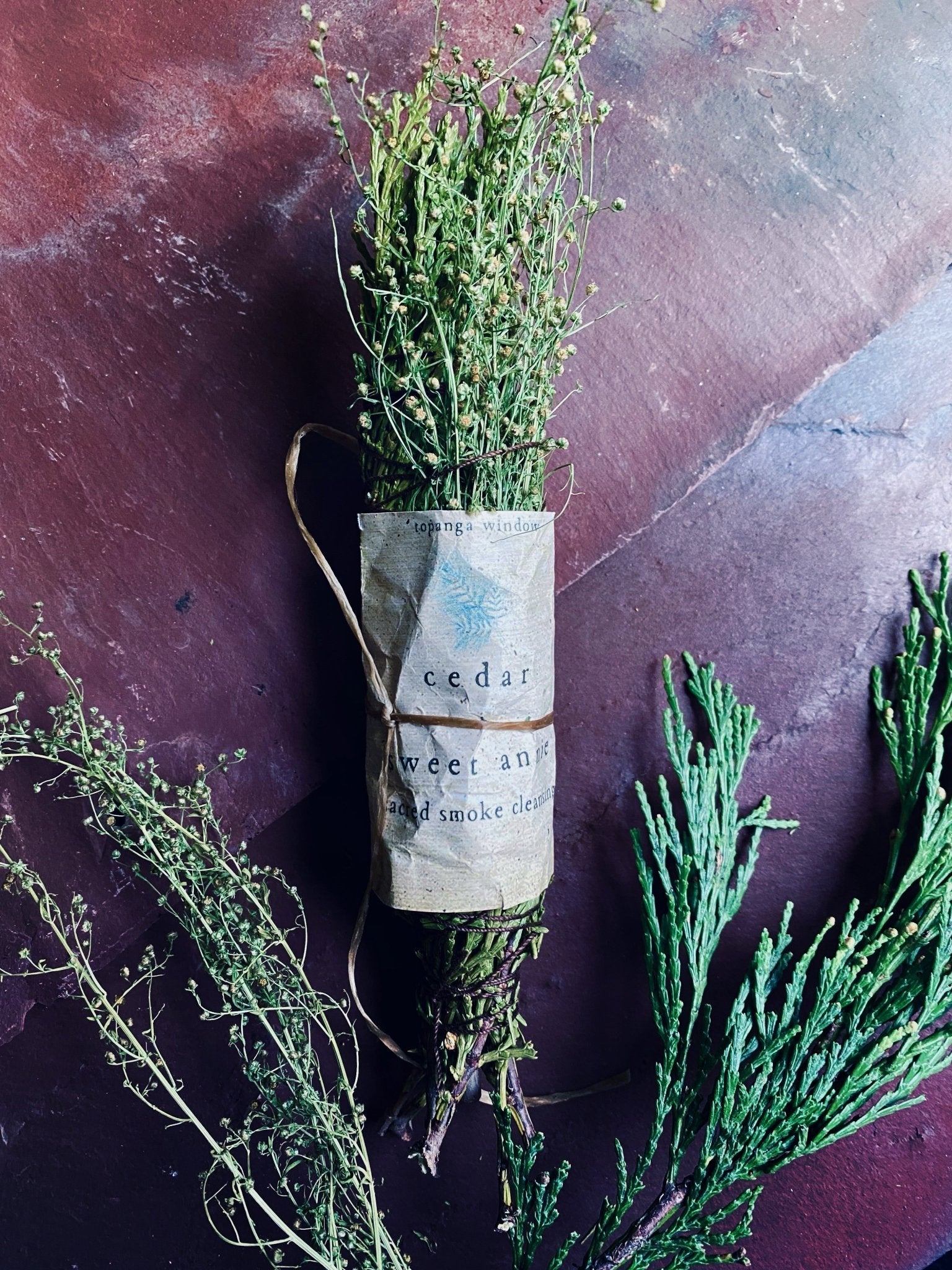 CEDAR STICK MADE WITH SWEET ANNIE.  BUNDLED TOGETHER WITH A WHITE PAPER LABEL AND BROWN ORGANIC THREAD.  uSED TO CLEANSE ENERGY IN SACRED SPACES OR YOUR HOME. 