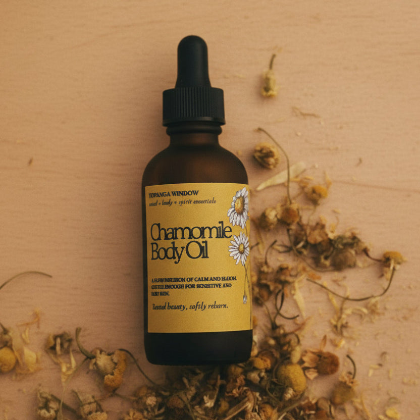 Bottle of chamomile body oil with dried flowers on a textured surface