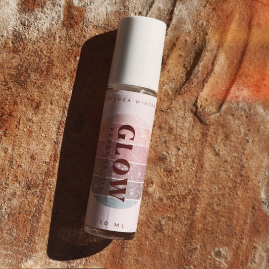 Small bottle labeled 'Glow' on a textured stone surface