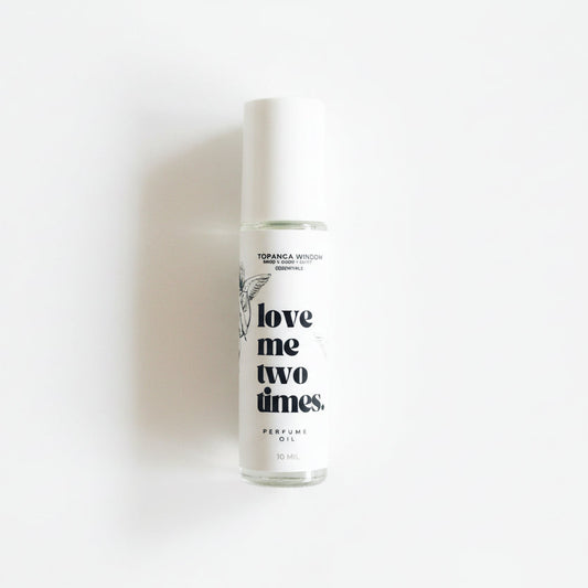 Perfume bottle labeled 'love me two times' on a white background