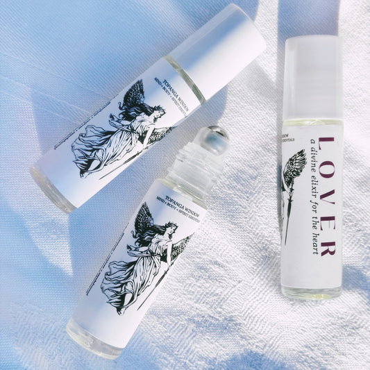 Three small bottles with angel illustrations on labels against a light blue background