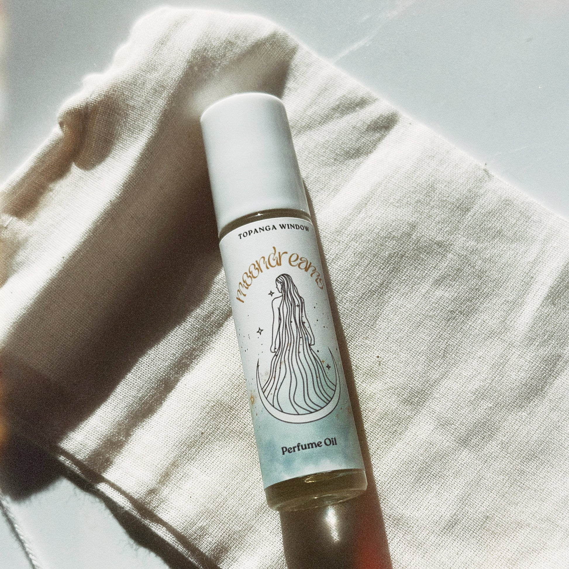 Perfume oil bottle with a label on a textured fabric background