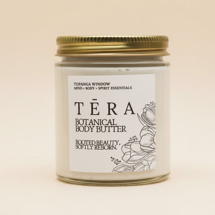 Téra botanical body butter jar with a gold lid on a textured white background