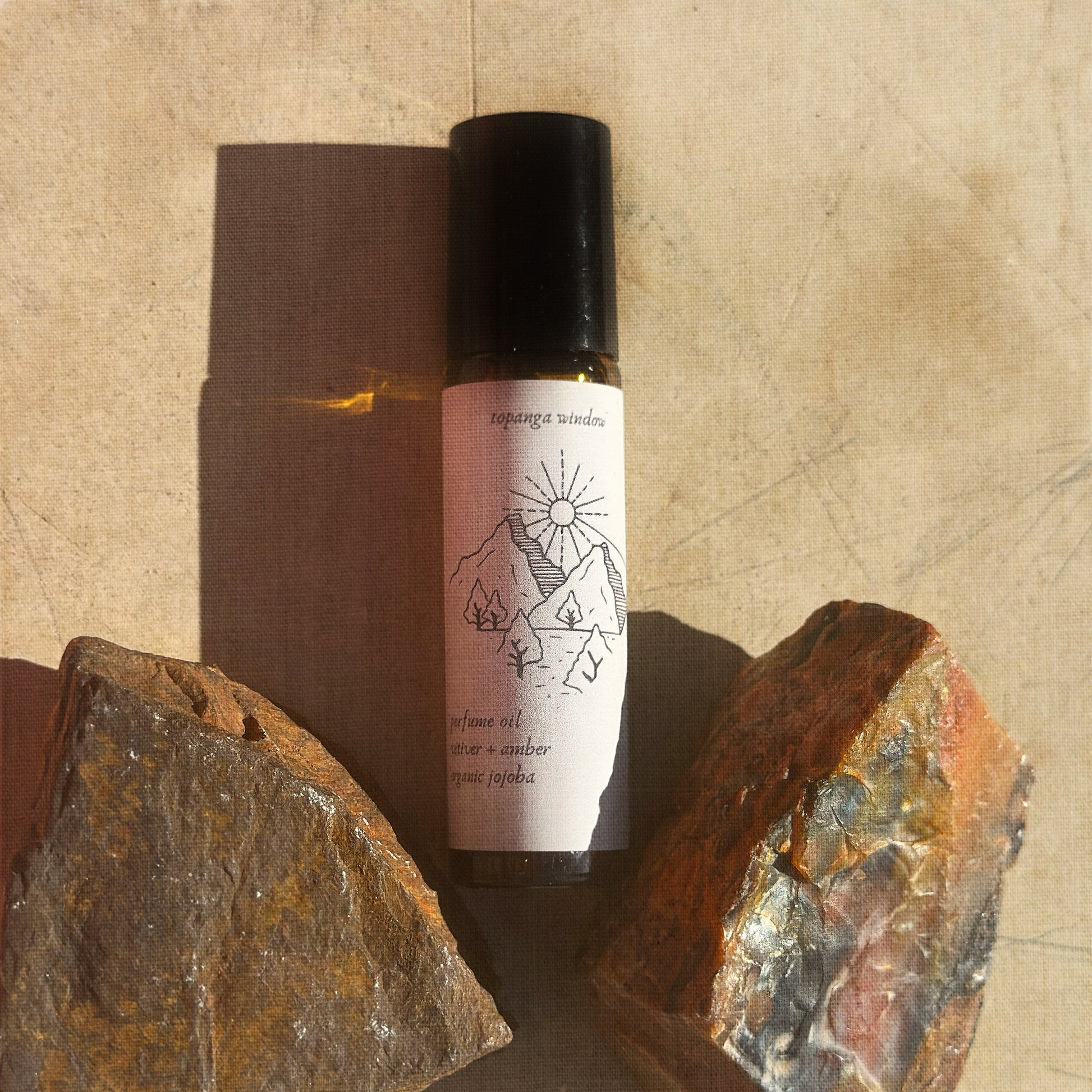 Small bottle with a tan label on a textured surface with rocks