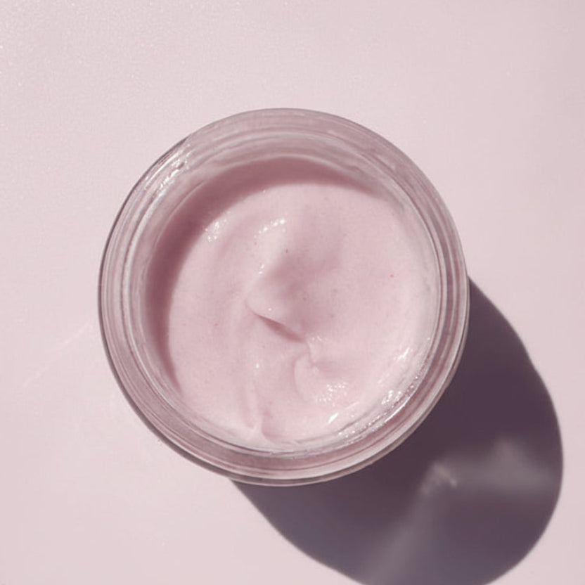 Jar of pink cream on a white background