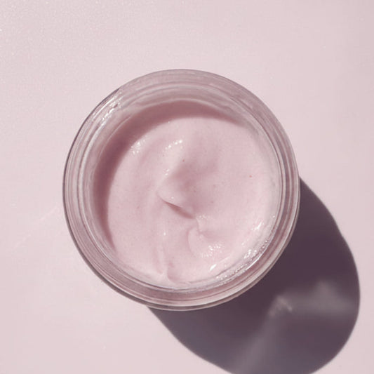 Jar of pink cream on a white background
