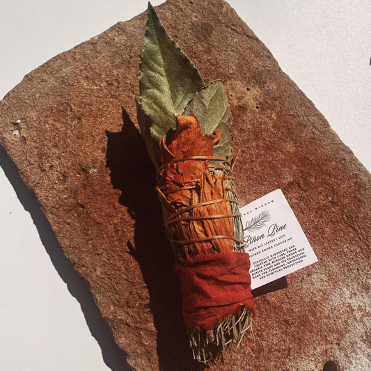 Smudge stick with leaves on a stone surface with a label