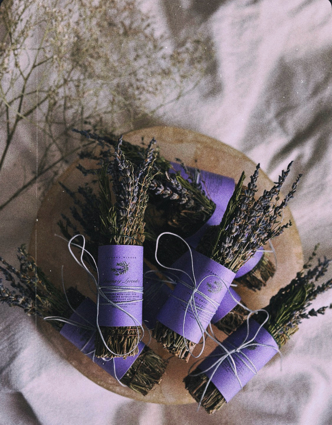 Bundles of lavender tied with purple ribbons on a wooden board.