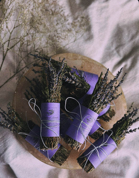Bundles of lavender tied with purple ribbons on a wooden board.