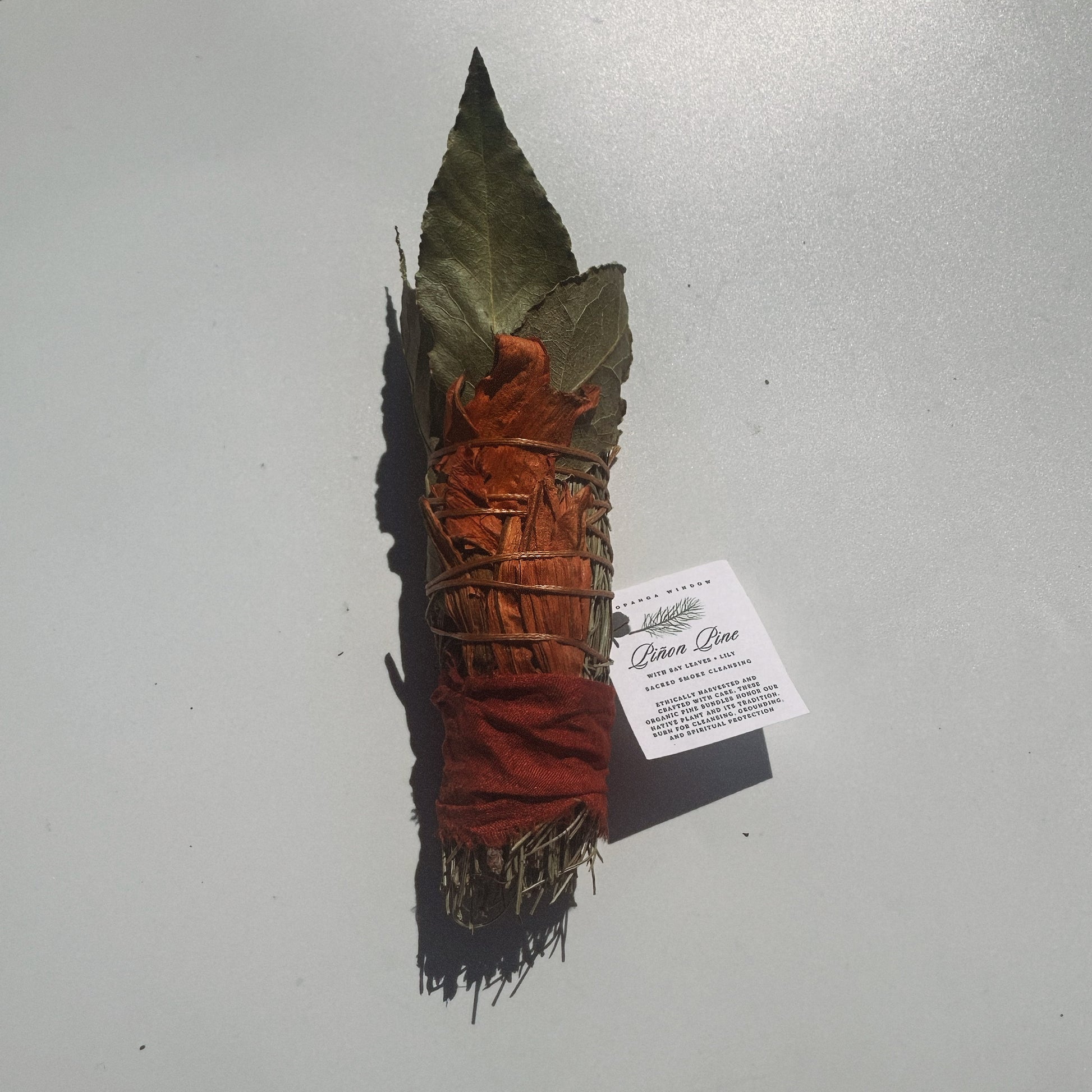 Woven leaf and fiber bundle with a label on a gray background