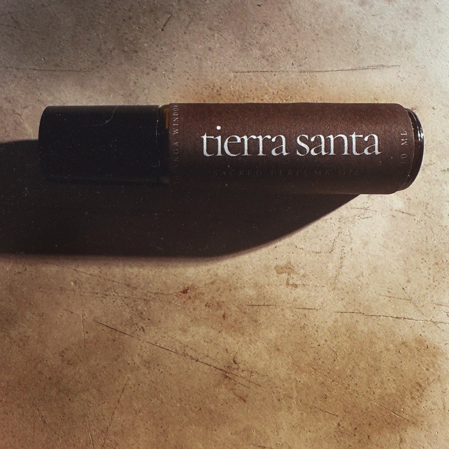 Tierra Santa perfume bottle on a rustic stone surface