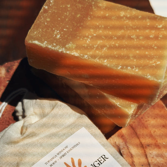 Tumeric Ginger vegan soap bar on a wooden surface with a label.