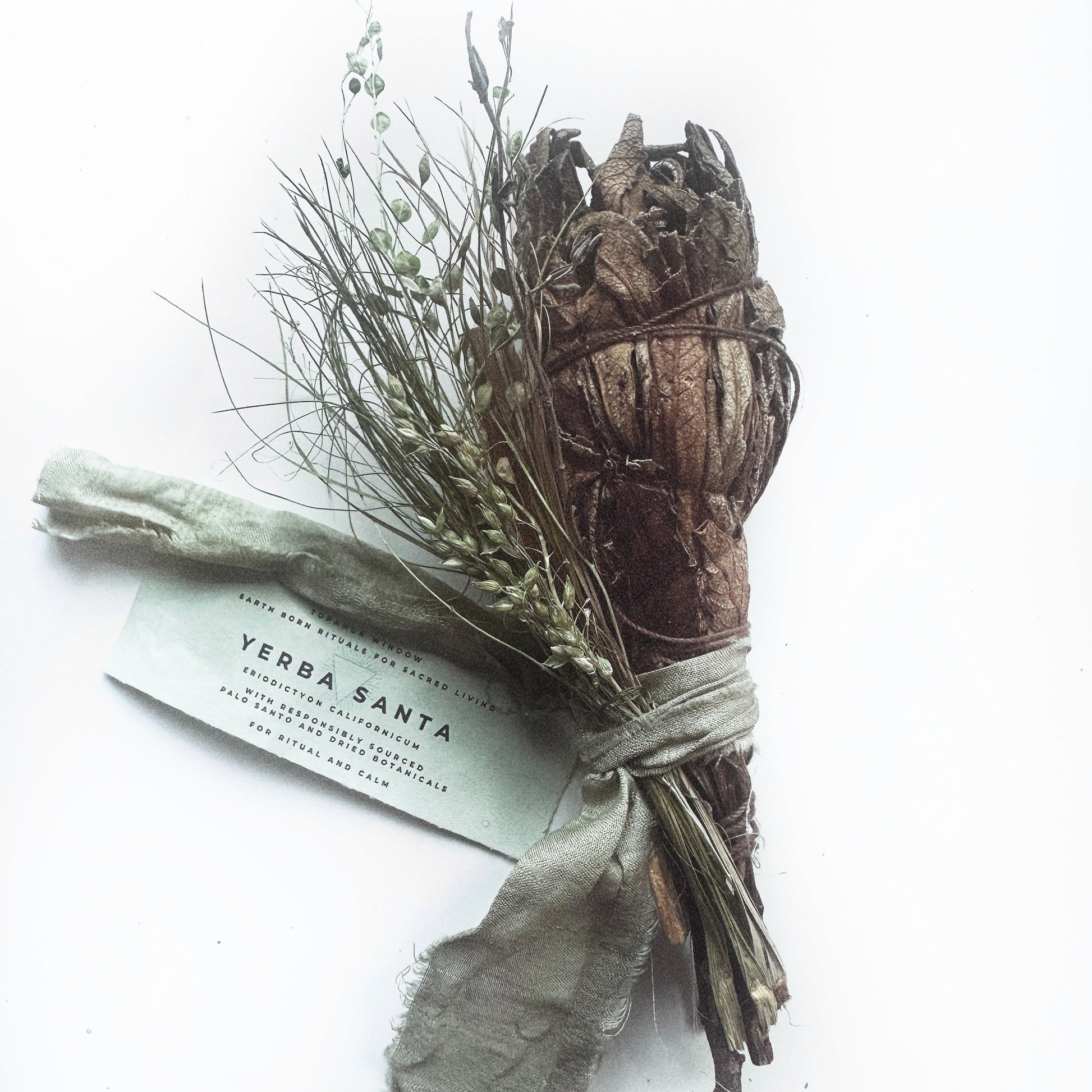 Smudge stick with herbs and a label on a white background